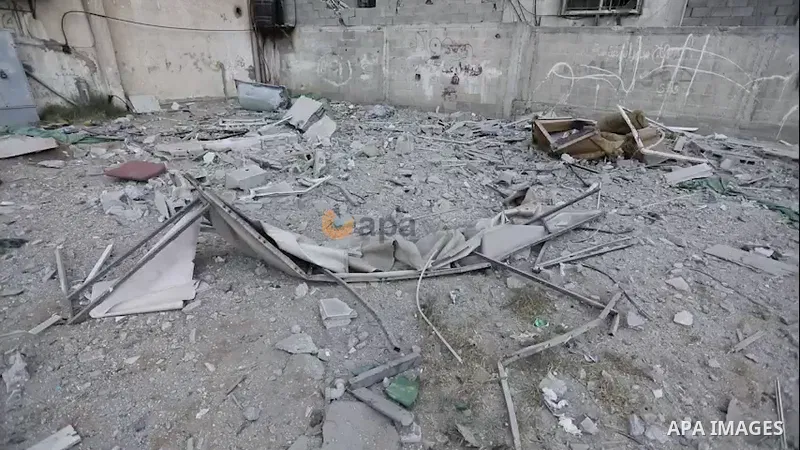 A Palestinian woman looks at the damage caused by an Israeli air strike in the vicinity of the 'Palestine Tower' in Gaza City. 0.1