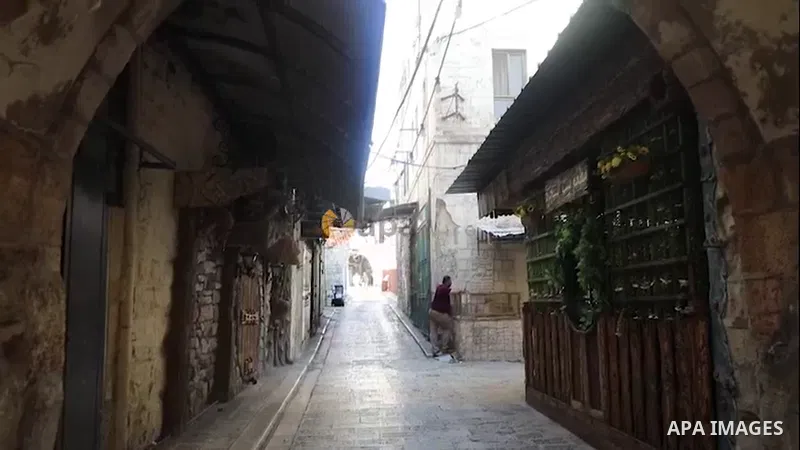 Palestinians walk near closed shops during a general strike, after Israeli forces killed Two Palestinians, in the West Bank city of Nablus.