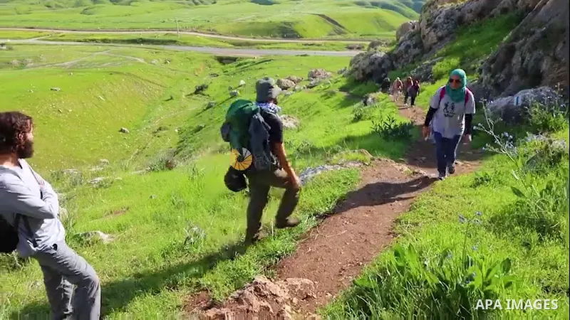 Palestinians walk amid cliffs during their journey in Wadi El-Feran, east the West Bank city of Tubas. 0.1