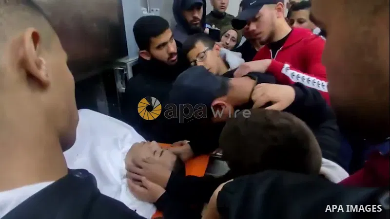 Palestinians carry the body of Mohammad Zakarneh, 17, who died of injuries sustained a day earlier during a raid by Israeli soldiers, during his funeral in the West Bank city of Jenin. 0.1