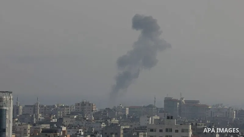 A plume of smoke rises above buildings in Gaza City during an israeli air strike.