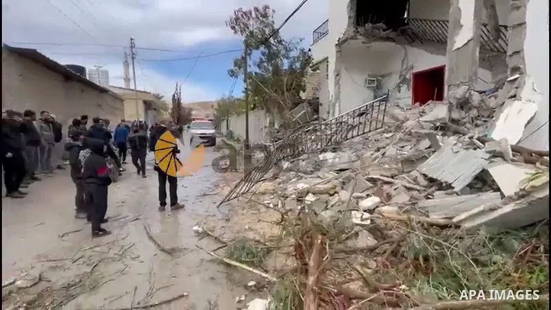 Palestinians check damage in a house which was destroyed by Israeli troops during a military raid in Jericho, in the West Bank.