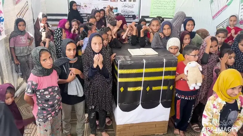 Displaced Palestinian children gather around a makeshift cube representing the holy Kaaba, in tent Inside a camp to shelter displaced persons in Al-Aqsa Martyrs Hospital, As part of training children how to perform Hajj...