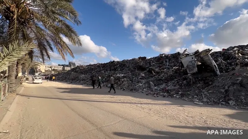 Palestinian youths search for salvageable items to reuse in a garbage dump that sprawls across what used to be the Firas market in Gaza City, on April 11, 2025.