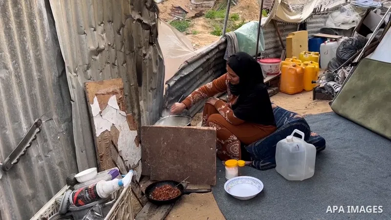 Palestinian Karam Abu Haloub and his wife Faten prepare iftar food during the third day of the holy month of Ramadan in a tent they set up on the ruins of their destroyed home in the Al-Shimaa area of ​​Beit Lahia in the...