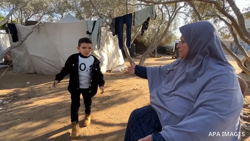 Palestinian child Sinan Abu Al-Ata, 6 years old, is being cared for by his grandmother in a tent inside a camp for displaced people in the Al-Zawaida area in the central Gaza Strip. Sinan is the only survivor of his fami...