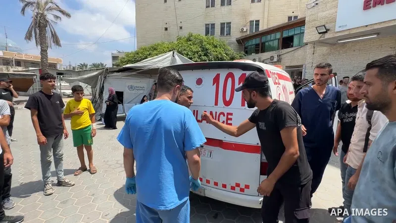 Medics transport the body of a Palestinian and several wounded people to Al-Aqsa Martyrs Hospital following an Israeli drone strike on the courtyard of a home.