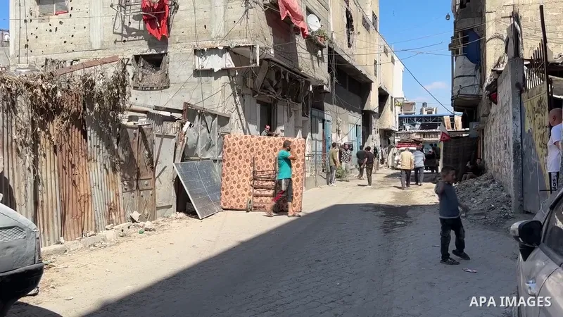 Restrictions Summary: APA wire clients only Shortlist: APAwire - APA wire clients only, Gaza- June 15, 2026. Palestinians carry their belongings as they flee the Al-Sanafour area in the Al-Tuffah neighborhood, east of Ga...