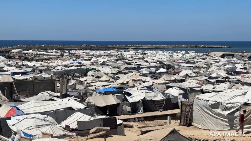 Restrictions Summary: APA wire clients only Shortlist: APAwire - APA wire clients only, Gaza- June 15, 2026. Displaced Palestinian Mohammed Zayed draws water from a hand-dug well near his tent in the Gaza City seaport ar...